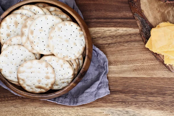 Rezsi Lövés Egy Tál Víz Sós Keksz Szeletelt Cheddar Sajt — Stock Fotó