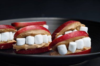 Çocuklar için eğlenceli yemek. Cadılar Bayramı elma ağız fıstık ezmesi dişler için mini marshmallow ile dolu. Sığ derinlik-in tarla merkezi tarih seçici odak ile tedavi. 