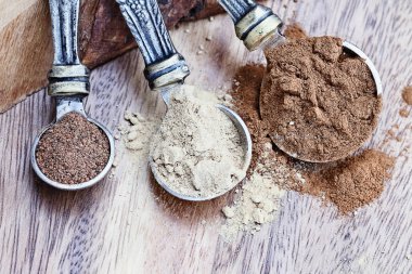 Kaşık ölçme rustik ahşap arka plan üzerinde kabak pasta baharat maddeler tarçın, zencefil ve Hindistan cevizi ile dolu. Tarçın tarih seçici odak ile alan aşırı sığ derinliği.
