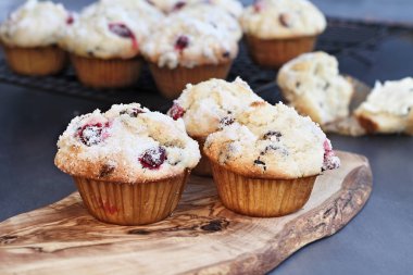 Yabanmersini Muffins limon şeker gevşek çilek ile bir rustik kesme tahtası üzerinde tepesi ile. Muffin ön planda tarih seçici odak ile alan aşırı sığ derinliği.