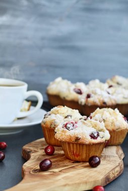 Daha fazla Fırıncılar rafına soğutma ile yabanmersini Muffins ağaç kesme tahtası. Muffin ön planda tarih seçici odak ile alan aşırı sığ derinliği. Dumanı tüten fincan sıcak kahve içinde belgili tanımlık geçmiş.