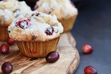 Yabanmersini Muffins limon şeker gevşek çilek ile bir rustik kesme tahtası üzerinde tepesi ile. Muffin ön planda tarih seçici odak ile alan aşırı sığ derinliği.