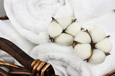 Çamaşır sepeti beyaz kabarık havlu ve pamuk Koza çiçek dolu. Bulanık arka plan ile ön plan odaklanmak.  