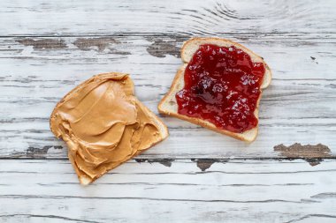 En iyi açık yüz ev yapımı fıstık ezmesi ve çilek reçelli sandviç görünümünü yulaf ekmek üzerinde beyaz bir rustik ahşap masa üzerinde / arka plan.