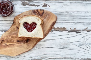 Ev yapımı fıstık ezmesi ve jöle sandviç görünümünü bir kesim kartı beyaz rustik Beyaz ahşap bir masa üzerindeki top / kalp merkezi dışarı kesim ile arka plan. Üstten Görünüm.