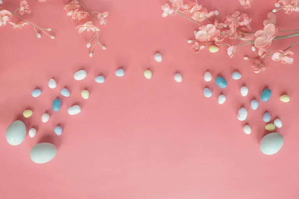 Pastello Uova di Pasqua Caramelle di malto e fiori su un corallo colorato B — Foto Stock