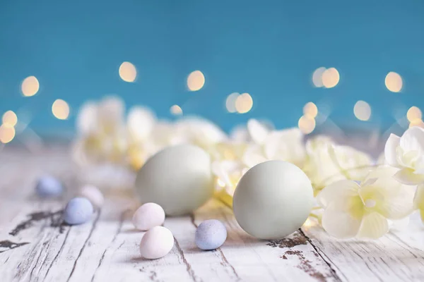 Easter Eggs mout snoep eieren en bloemen achtergrond — Stockfoto
