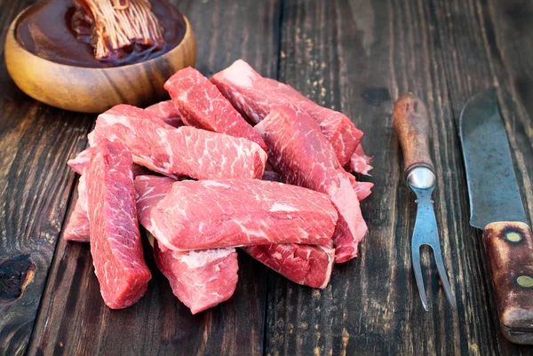 Сырые говяжьи ребрышки со старинной вилочкой и мясным ножом — стоковое фото