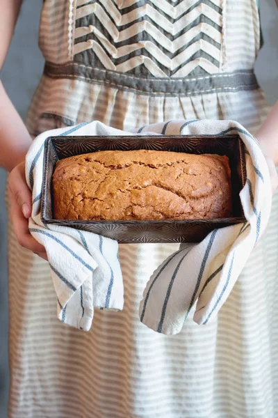 Womans hand hålla en limpa pumpa bröd — Stockfoto