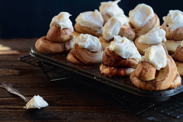 Lång gourmet kanelbullar med glasyr i en muffin Tin — Stockfoto