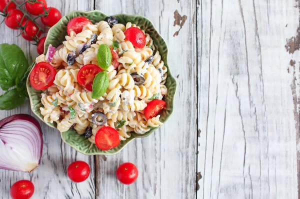 Bovenaanzicht Van Pastasalade Met Vers Gehakte Basilicum Tomaten Zwarte Olijven — Stockfoto