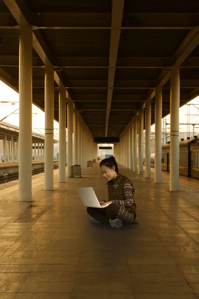 早上在火车站使用笔记本电脑的女孩 在中国 — 图库照片