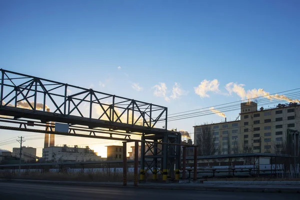 Factory steam in the sunset sun