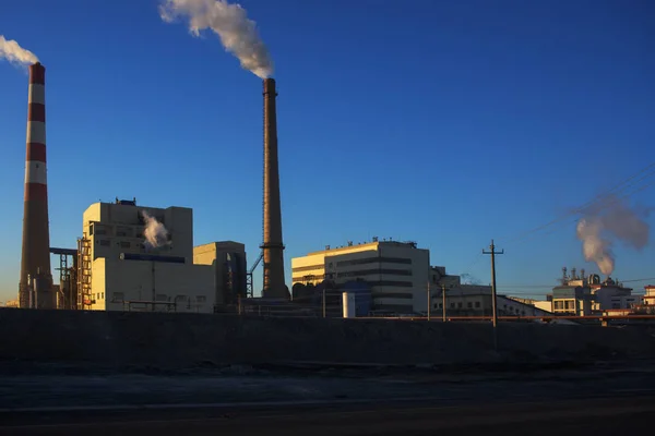 Factory cooling tower steam at sunset