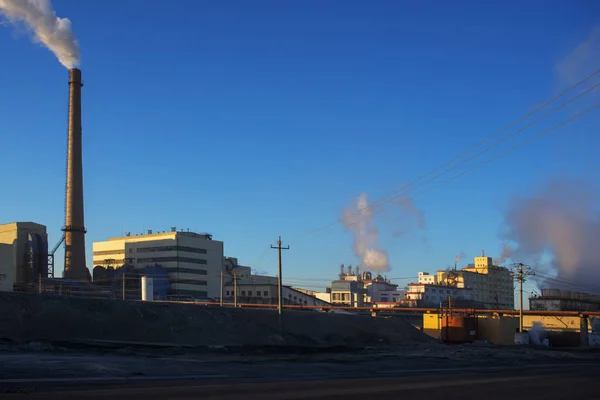 Factory cooling tower steam at sunset