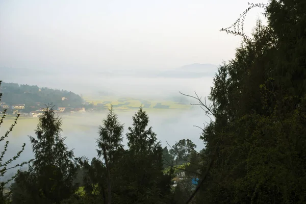 El pueblo de montaña en la niebla de la mañana — Foto de Stock