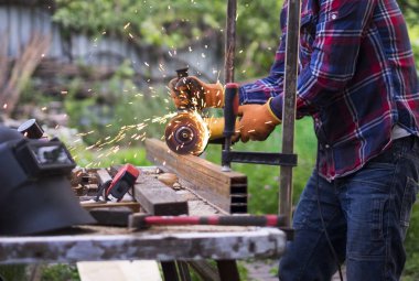 Bir açı değirmeni ile bir adam kesme metal konstrüksiyon