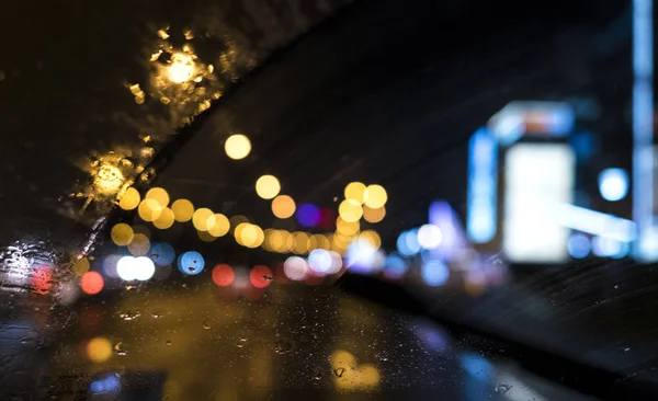 colorful lights through a wet car window in a night city