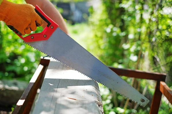 Mano en un guante aserrado tablón de madera, fondo de verano — Foto de Stock