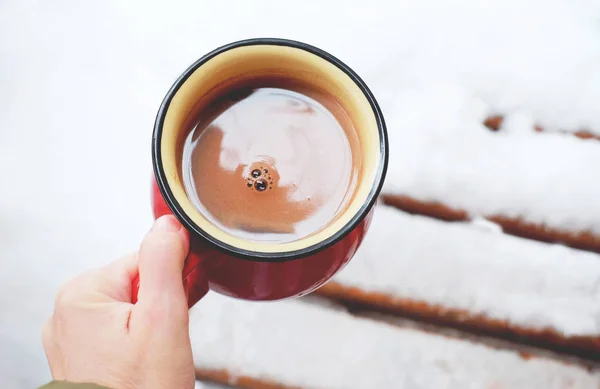 Kubek do kawy w dłoni na tle śniegu — Zdjęcie stockowe