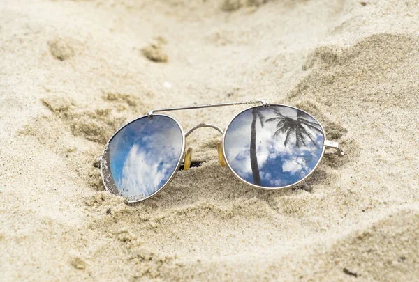 Óculos de sol espelhados fecham na areia da praia com reflexo de palmeiras — Fotografia de Stock