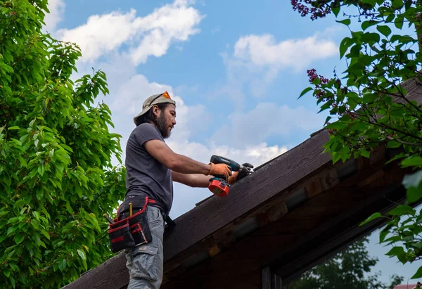 Hombre trabajando en el techo usando destornillador eléctrico — Foto de Stock