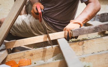 Tahta testereyle tahta kesen bir adam..