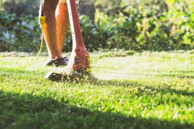 Çim biçme makinesi kullanan bir adam