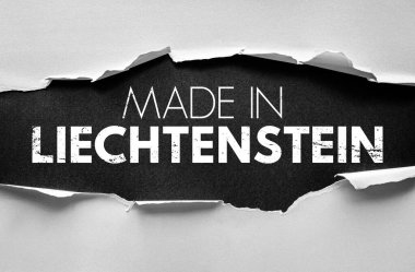 Yırtık kağıdın altında koyu, sıkıntılı beyaz yazı tipiyle Liechtenstein metninde yapılmış. Üretim, ticaret, ihracat, özgünlük, markalaşma, ulusal üretim, ekonomi ve tedarik zinciri kavramı