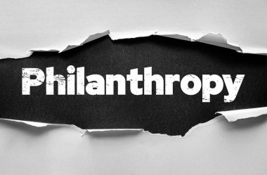 Sözcük hayırseverliği, yırtık kağıt arkaplanından ortaya çıkan kalın harflerle yazıldı. Bağış, bağış, cömertlik, kar amacı gütmeyen iş, bağış ve başkalarına yardım imajı