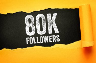 Yırtık kağıt arkaplanda 80K FOLLOWERS metni bulundu. Büyümeyi, popülerliği, çevrimiçi topluluğu, dijital başarıyı ve seyirci katılımını kutlayan sosyal medya kilometre taşı kavramı