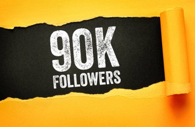 Yırtık kağıt arkaplanda 90K FOLLOWERS metni bulundu. Büyümeyi, çevrimiçi popülerliği, dijital başarıyı, toplumsal bağlılığı ve marka varlığını sembolize eden sosyal medya kilometre taşı kavramı