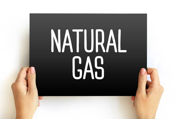 Natural Gas text on card held by hands. Conceptual image symbolizing fossil fuels, energy resources, heating, fuel supply, and industrial power production themes