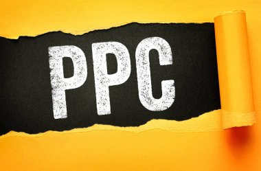 PPC letters revealed on torn paper background. Concept for pay per click advertising, digital marketing, online campaigns, business promotion, and internet-based strategies