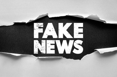Yırtık kağıdın altında kalın grunge yazı tipiyle sahte haber mesajı. Yanlış bilgilendirme, medya güven sorunları, propaganda, gerçekleri kontrol etme ve çevrimiçi farkındalık yayma kavramı