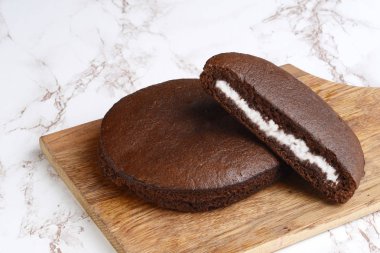 bir ahşap kesme tahtası üzerinde çikolata kremalı kek