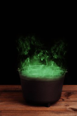 black halloween cauldron with green smoke clipart