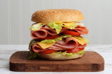 Yakın plan jambonlu, peynirli, domatesli, bagelli sandviç.