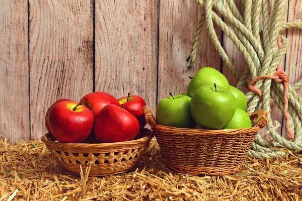 在干草捆上的篮子里贴上红绿相间的苹果 — 图库照片