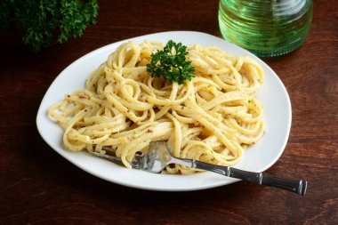 Beyaz krema soslu spagetti ve çatal.