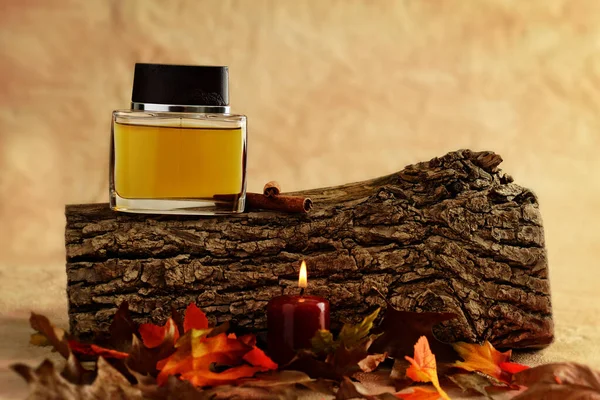 Parfüm şişesi ahşap kütükte kırmızı mum ile