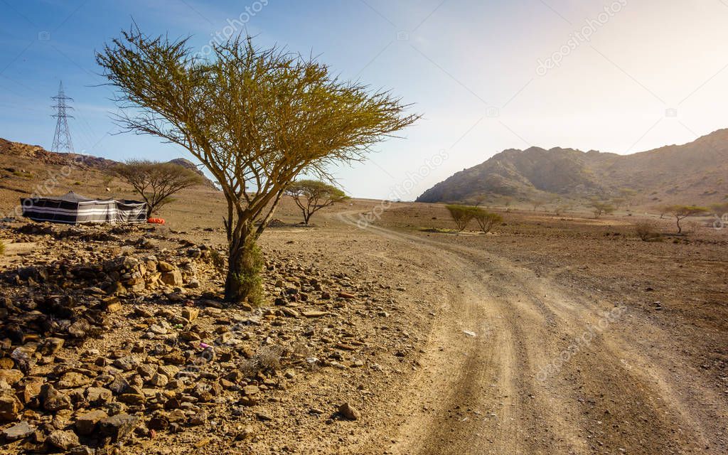 Dirt road in Al Hajar mountains in Fujairah, UAE and a tent