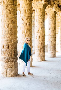 Kadın bir colonnade Park Guell Barcelona içinde yürürken