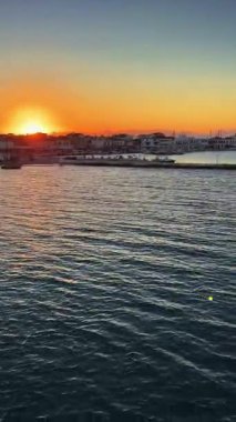 Yunanistan 'daki Elafonisos Adası limanında günbatımını gösteren dikey video klibi
