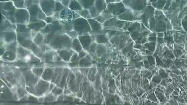 Güneş ışığı basamaklara yansıyor ve temiz bir yüzme havuzunun boşaltılması güzel dalgalanma desenleri yaratıyor. Huzurlu yaz anı, sağlık, spa, tatil ve minimalizm kavramları için mükemmel.