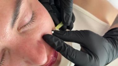 Yüz gerdirme PDO dikiş operasyonu. Yeni iplik kaldırmanın yenilikçi tekniği, kozmetolog kadın müşteriye prosedür uygulamaya hazırlanıyor, uygun iplik seçeneğini seçin. Yüksek kalite 4k görüntü