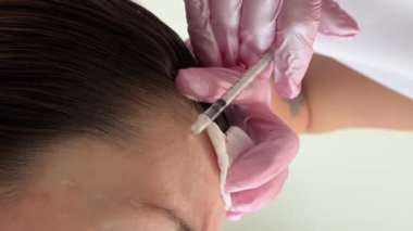 Güzellik kliniği. Eldiven giymiş güzellik uzmanları kadın derisine yüz yaşlanma enjeksiyonu yapıyor. Bir kadın güzellik yüz kozmetolojisi prosedürünü uygular. Botoks. Kolajen enjeksiyonları. 