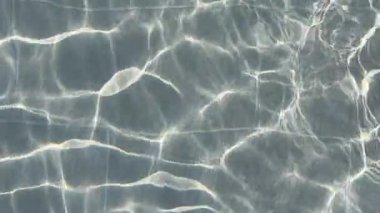 Güneş ışığı basamaklara yansıyor ve temiz bir yüzme havuzunun boşaltılması güzel dalgalanma desenleri yaratıyor. Huzurlu yaz anı, sağlık, spa, tatil ve minimalizm kavramları için mükemmel.