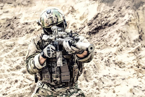 Soldado do exército moderno apontando e atirando no deserto — Fotografia de Stock