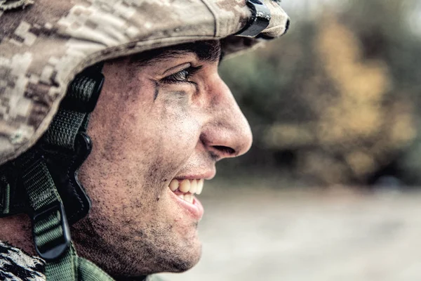 Porträtt av leende soldat i trasiga hjälm — Stockfoto